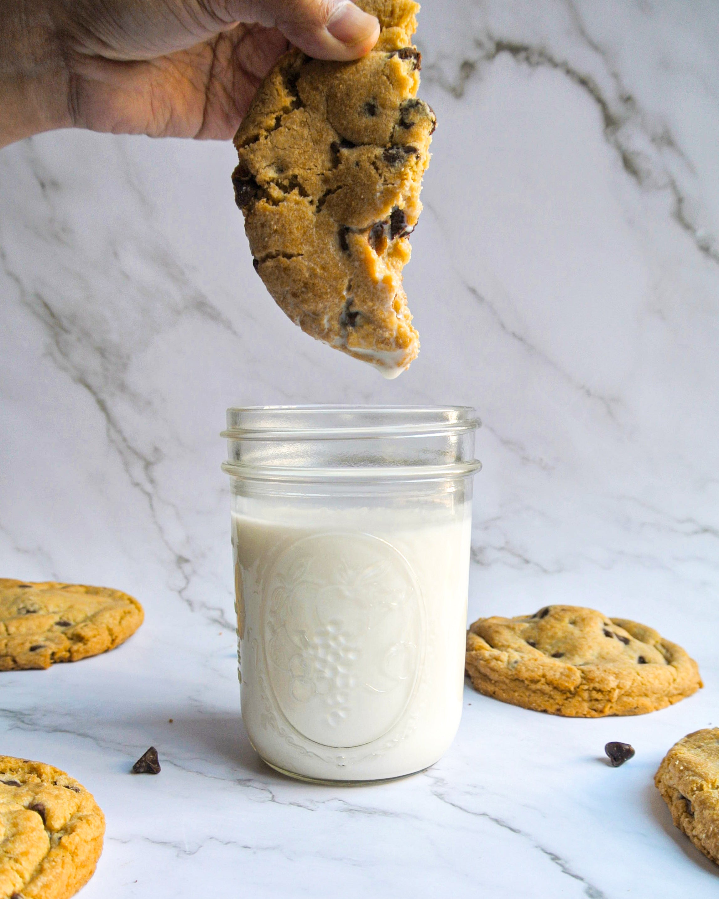 alt="Chocolate chip cookie being dunked into fresh cold milk - Choc Cookies' signature homestyle cookies baked fresh daily in Santa Clara, perfect for corporate events and family celebrations in Silicon Valley"